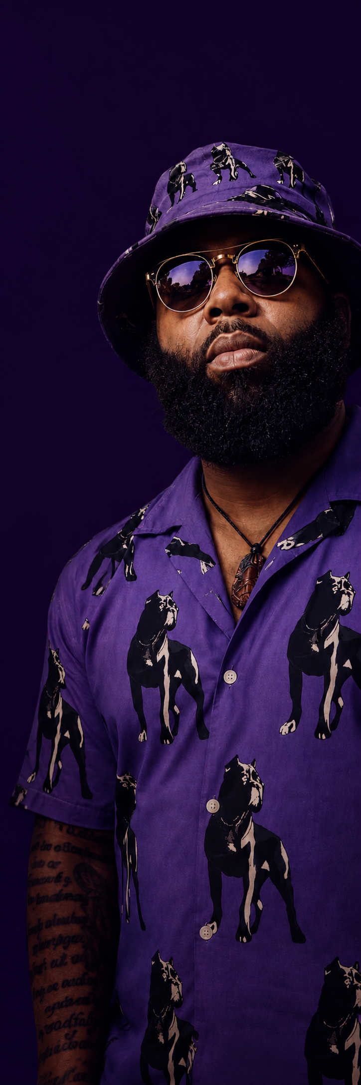 King Tee Mulaa wearing a purple shirt, matching hat and sunglasses