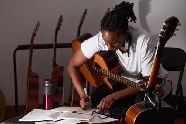 Songwriter working through lyrics with a guitar