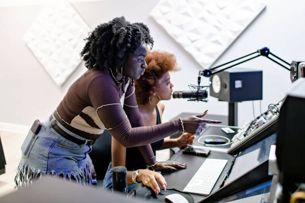 Two independent music creators collaborating at a studio console