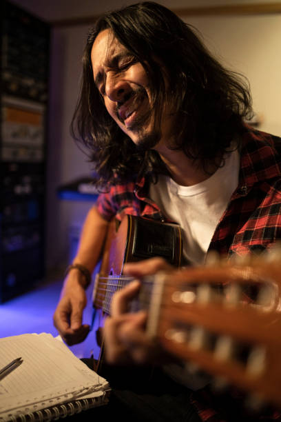 Guitarist singing intensely while working through a song