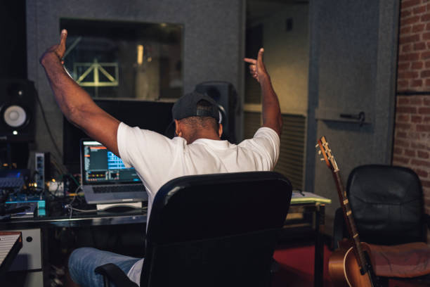 Producer reacting inside a recording studio with both arms raised